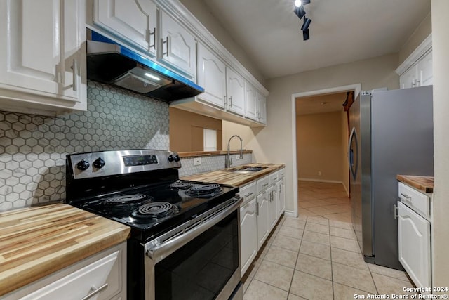 kitchen with sink, wood counters, decorative backsplash, white cabinets, and appliances with stainless steel finishes