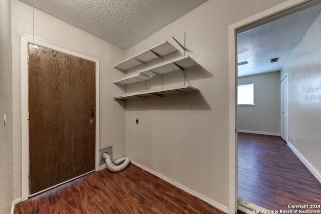 washroom featuring a textured ceiling, dark hardwood / wood-style floors, and electric dryer hookup