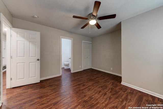 unfurnished bedroom featuring dark hardwood / wood-style floors, ceiling fan, and connected bathroom