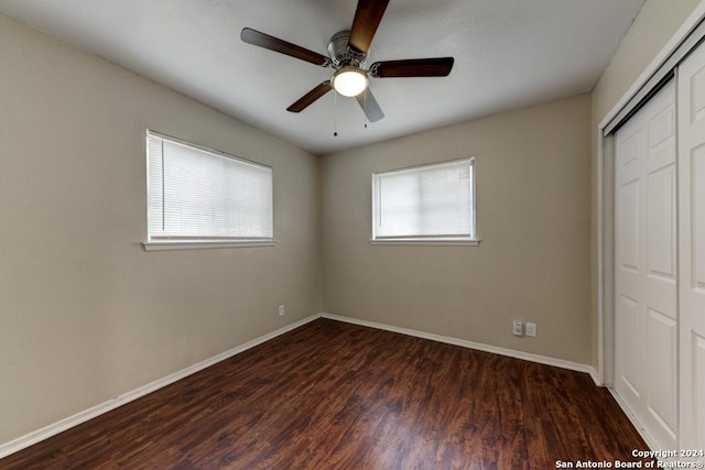 unfurnished bedroom featuring ceiling fan, dark hardwood / wood-style floors, and a closet