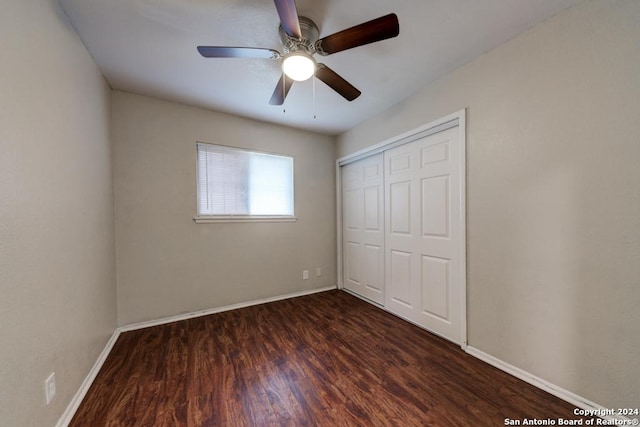 unfurnished bedroom featuring ceiling fan, a closet, and dark hardwood / wood-style floors