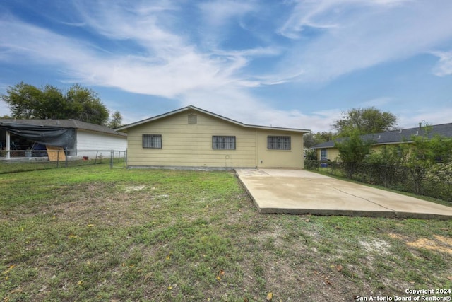 rear view of property featuring a yard and a patio area