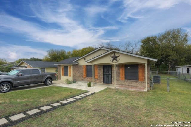 ranch-style home featuring central air condition unit and a front yard