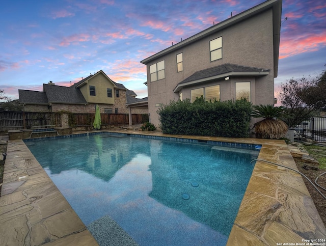 view of pool at dusk