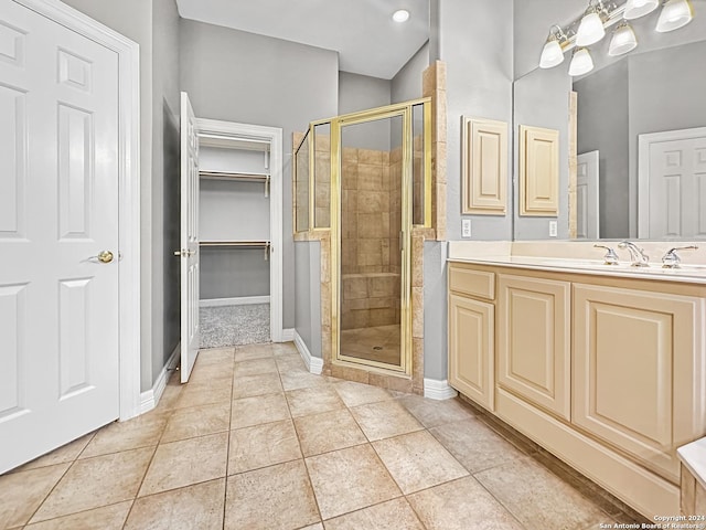 bathroom with tile patterned flooring, vanity, and a shower with door