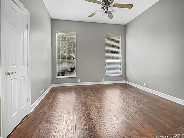 empty room with dark hardwood / wood-style floors and ceiling fan