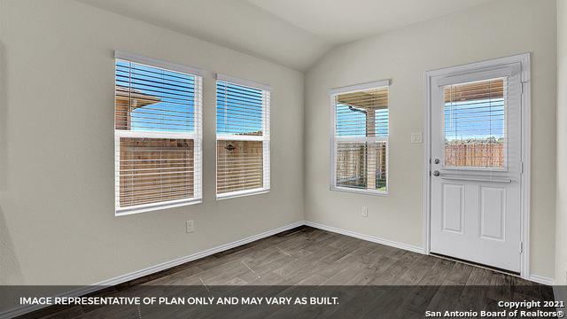 spare room featuring wood-type flooring and vaulted ceiling