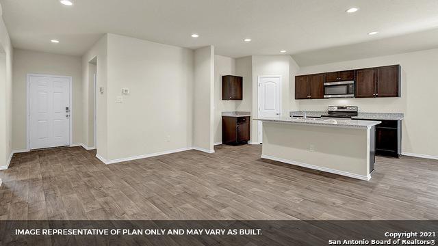 kitchen with dark brown cabinets, a kitchen island with sink, appliances with stainless steel finishes, and light hardwood / wood-style flooring