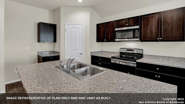 kitchen featuring lofted ceiling, dark wood-type flooring, sink, appliances with stainless steel finishes, and dark brown cabinets