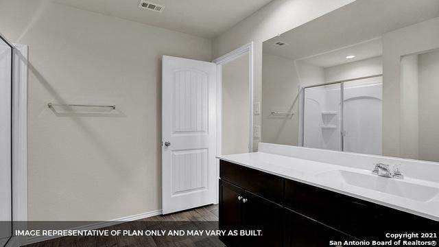 bathroom featuring wood-type flooring, vanity, and walk in shower