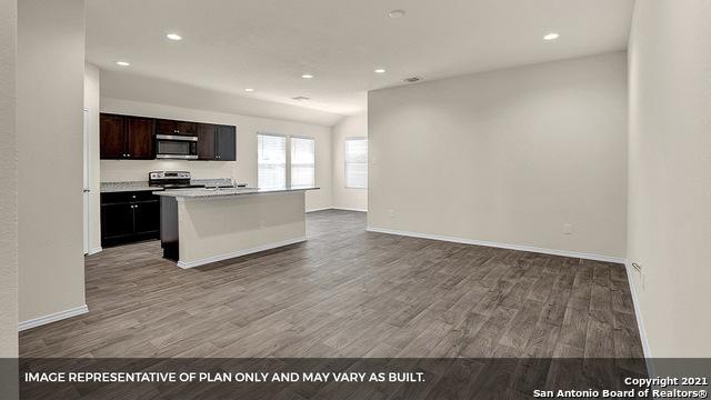 kitchen with a center island with sink, stainless steel appliances, dark brown cabinets, and wood-type flooring