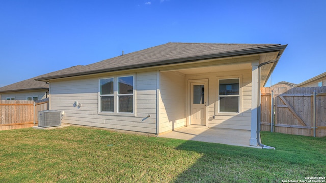 rear view of property featuring a lawn, central air condition unit, and a patio