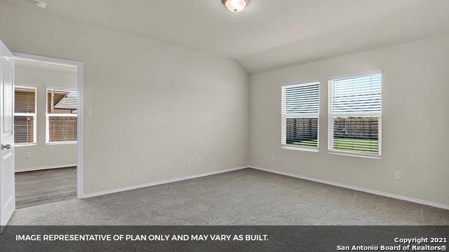 carpeted spare room featuring vaulted ceiling