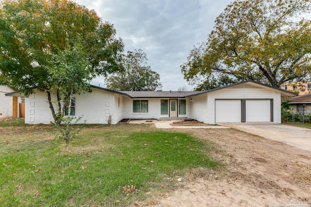 ranch-style home with a garage and a front yard