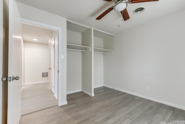 unfurnished bedroom with a closet, light hardwood / wood-style flooring, and ceiling fan