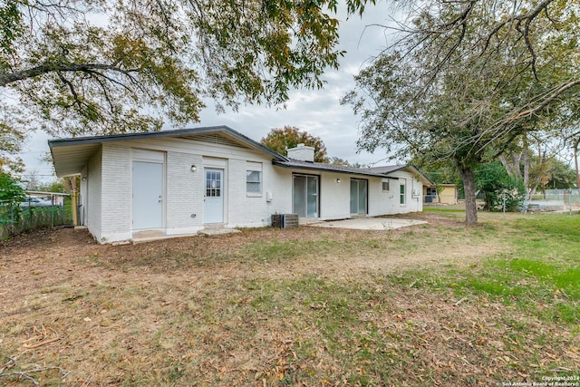 back of property featuring central air condition unit, a yard, and a patio