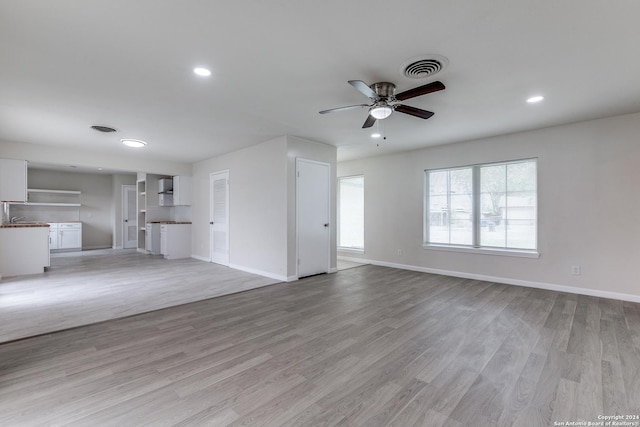 unfurnished living room with light wood-type flooring and ceiling fan