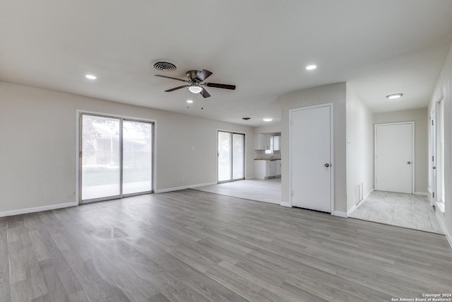 unfurnished living room featuring ceiling fan and light hardwood / wood-style flooring