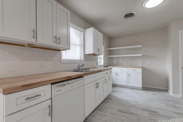 kitchen featuring butcher block countertops, white cabinets, sink, and white dishwasher