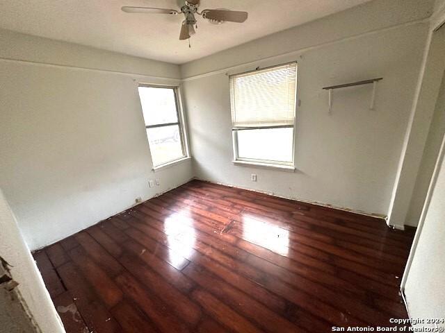 spare room with ceiling fan and dark wood-type flooring