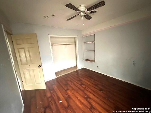 unfurnished bedroom featuring dark hardwood / wood-style flooring, a closet, and ceiling fan