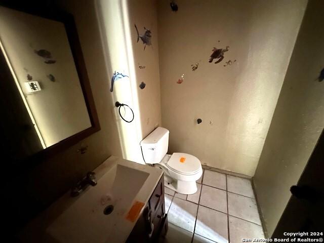 bathroom featuring tile patterned flooring, vanity, and toilet