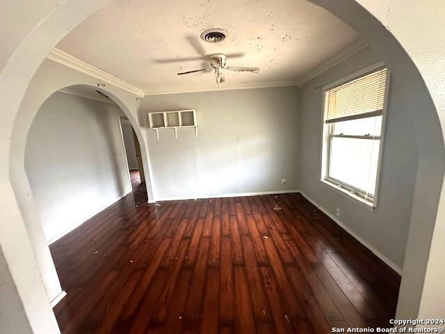 spare room featuring ceiling fan, dark hardwood / wood-style flooring, and crown molding