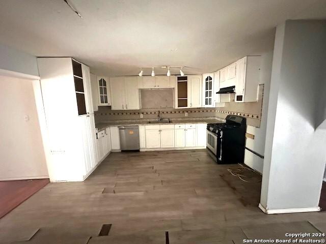 kitchen with decorative backsplash, white cabinetry, dishwasher, and black range oven