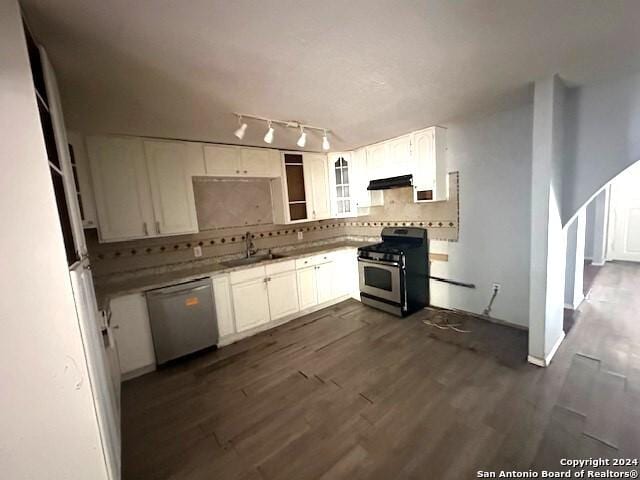 kitchen with backsplash, white cabinets, ventilation hood, appliances with stainless steel finishes, and dark hardwood / wood-style flooring