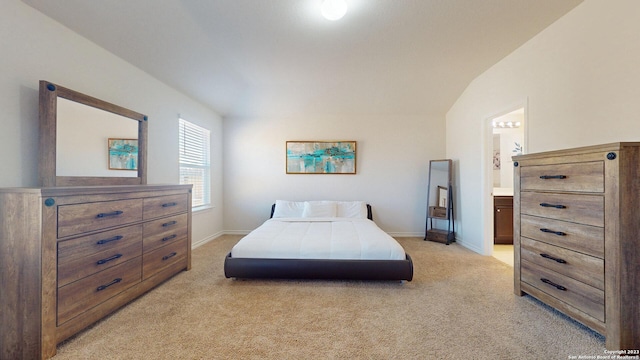 carpeted bedroom with connected bathroom and vaulted ceiling