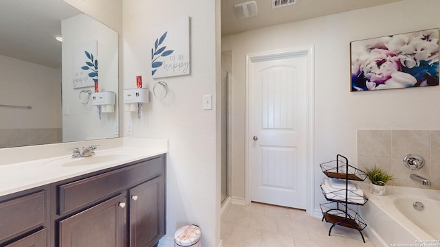 bathroom featuring tile patterned floors, vanity, and a tub to relax in