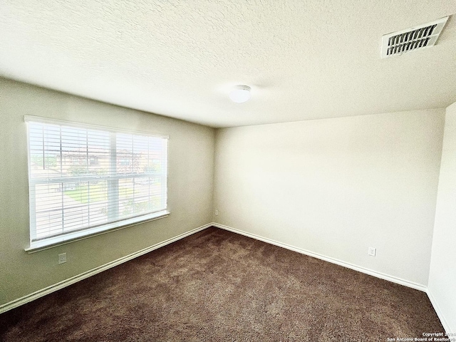 carpeted spare room featuring a textured ceiling