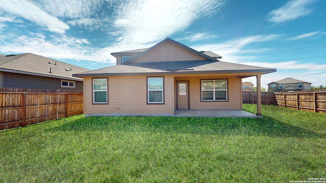 rear view of house with a lawn and a patio