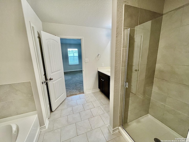 bathroom with tile patterned flooring, vanity, a textured ceiling, and shower with separate bathtub