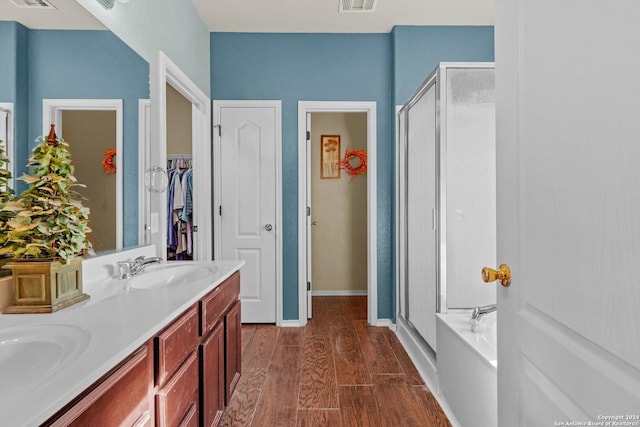 bathroom with hardwood / wood-style floors, vanity, and shower with separate bathtub