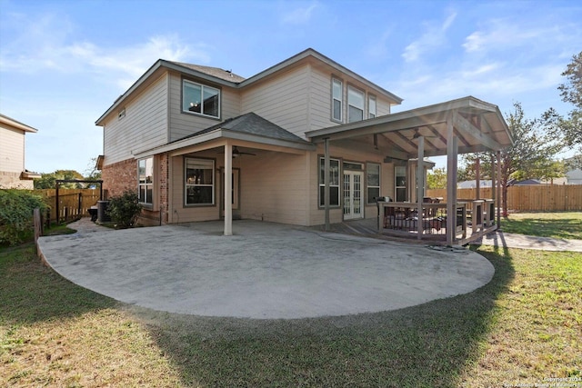 rear view of property featuring a lawn, ceiling fan, and a patio