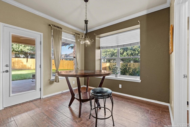 dining room with hardwood / wood-style floors, plenty of natural light, and crown molding