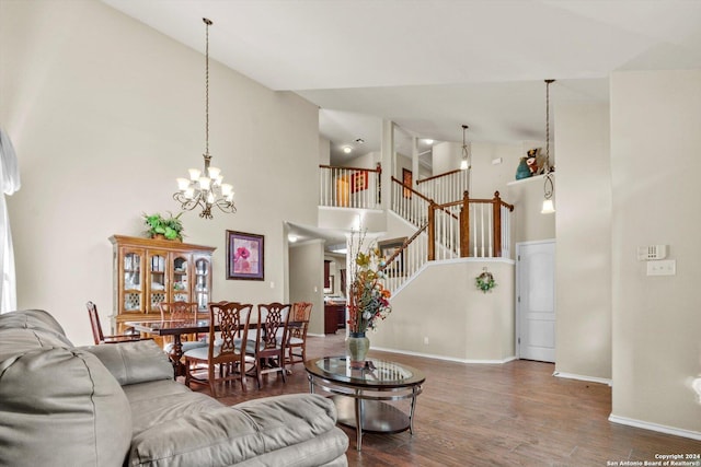 living room featuring a chandelier, high vaulted ceiling, and dark wood-type flooring