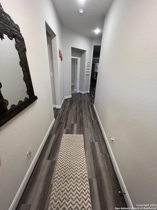 corridor with dark hardwood / wood-style flooring