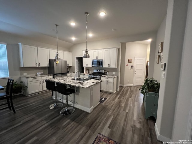 kitchen featuring white cabinetry, stainless steel appliances, hanging light fixtures, and an island with sink