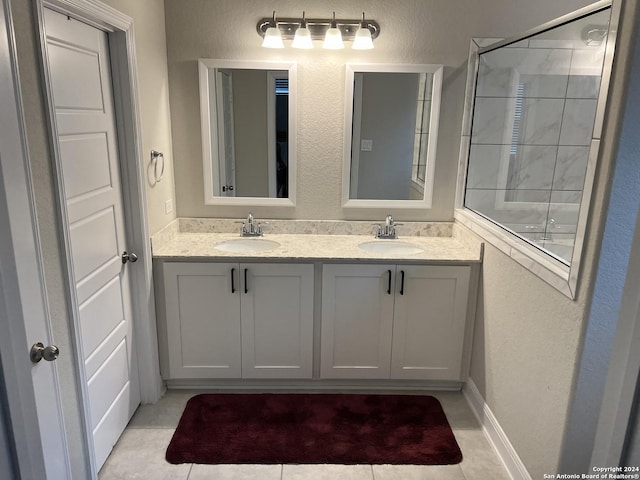 bathroom with tile patterned floors, vanity, and a tile shower