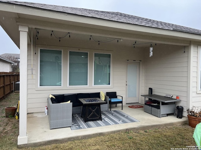 rear view of property with a patio area and an outdoor living space with a fire pit