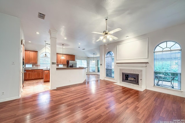 unfurnished living room featuring ceiling fan, plenty of natural light, and light hardwood / wood-style floors