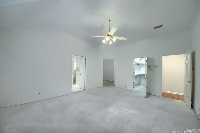 unfurnished bedroom with lofted ceiling, crown molding, ceiling fan, a spacious closet, and connected bathroom