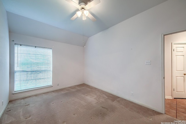 carpeted empty room featuring ceiling fan and vaulted ceiling