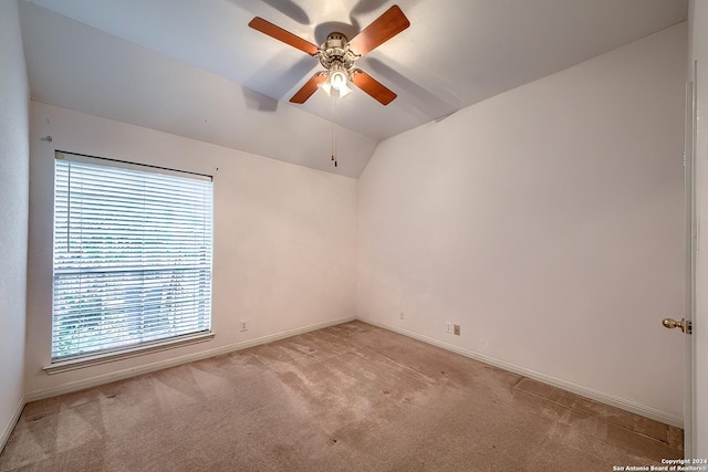 carpeted empty room featuring ceiling fan, a wealth of natural light, and vaulted ceiling