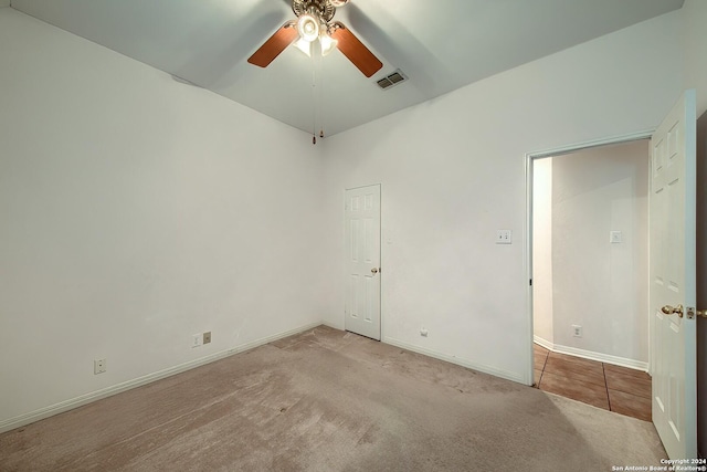 carpeted spare room with ceiling fan