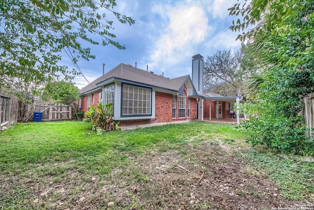 back of property with a yard and a patio