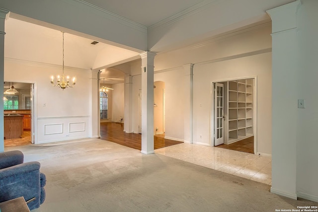 carpeted living room with ornamental molding, built in features, a chandelier, plenty of natural light, and lofted ceiling