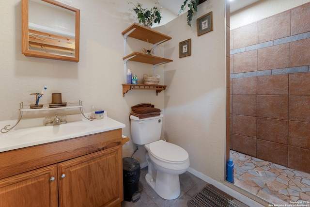 bathroom featuring tile patterned floors, vanity, tiled shower, and toilet